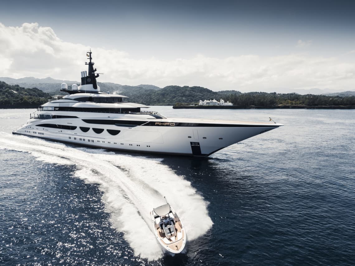 Large Yacht Cruising Deep Blue Waters with a Small Boat Speeding By