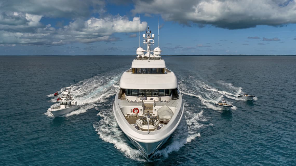 Yacht Facing Forward with Smaller Boats Flanking its Sides