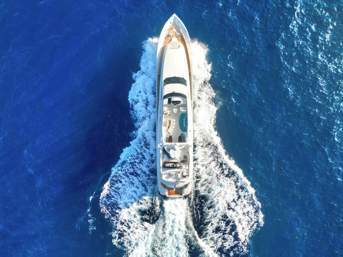birds-eye view of yacht of bright blue waters