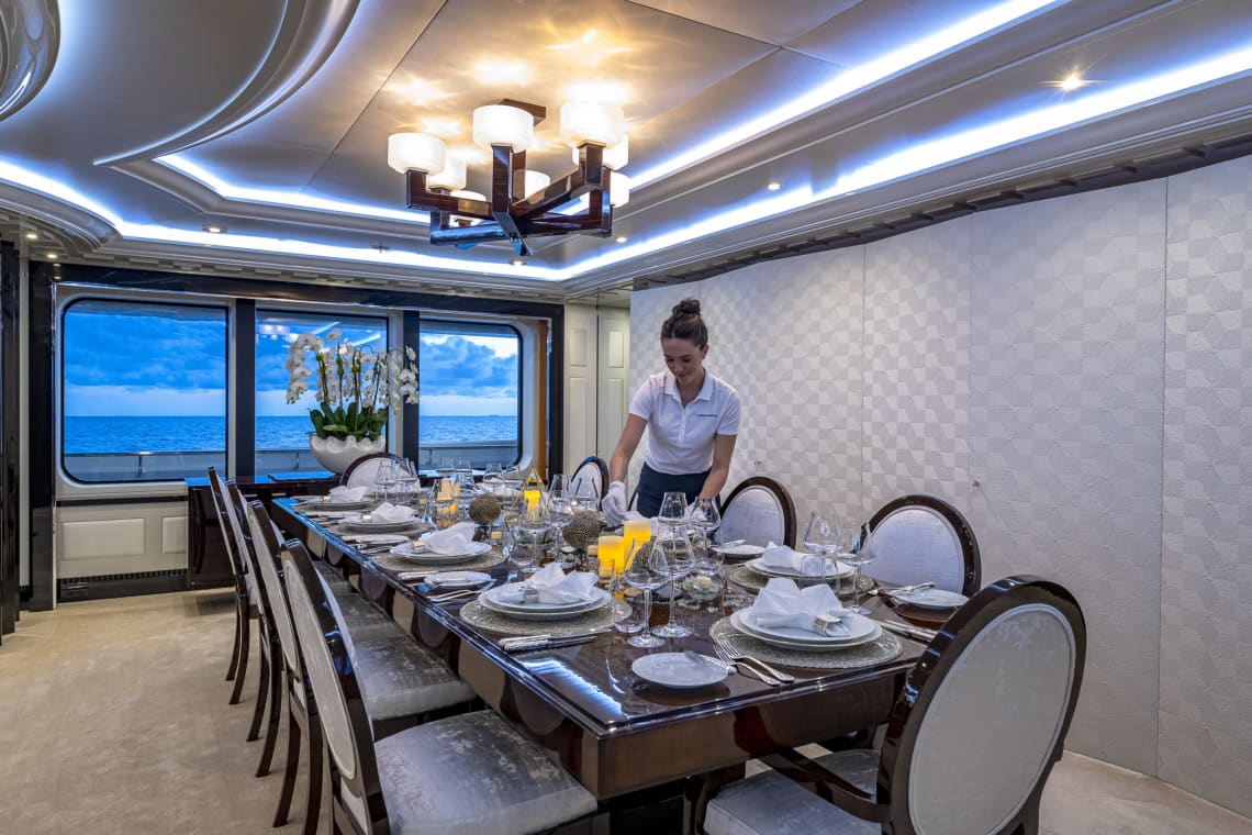 Woman Crew Member Setting a Dinner Table on a Yacht