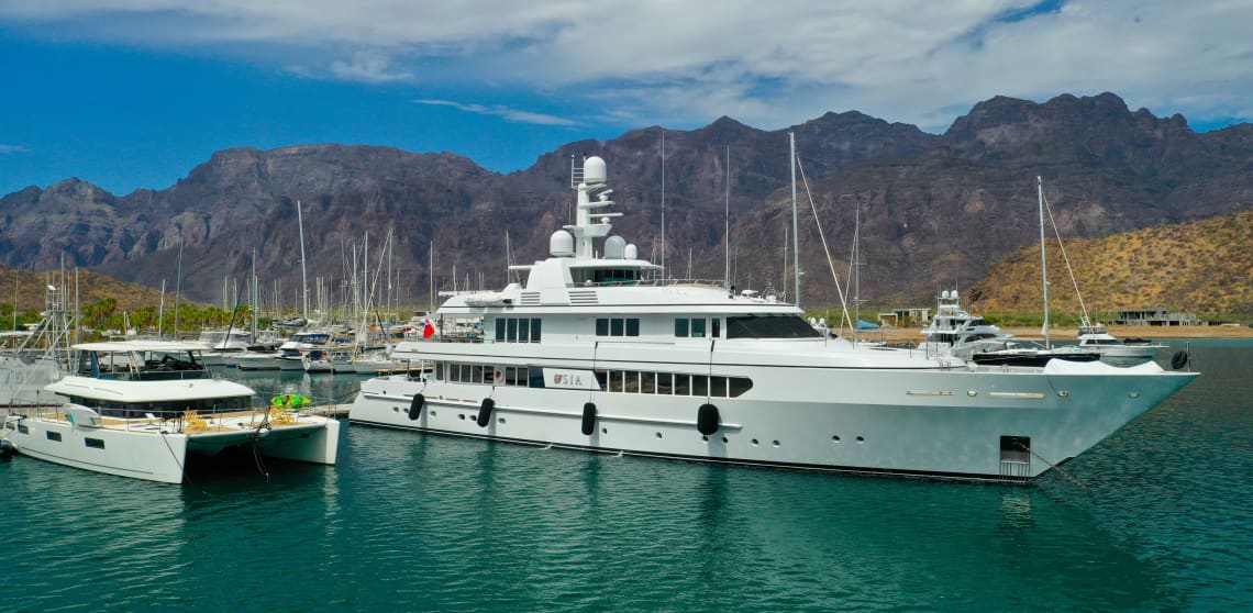 A Yacht Docked in a Marina with Other Smaller Boats