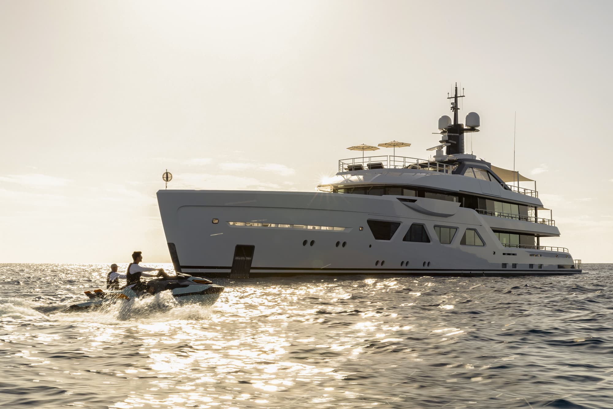 Yacht with 2 people on a jetski next to it