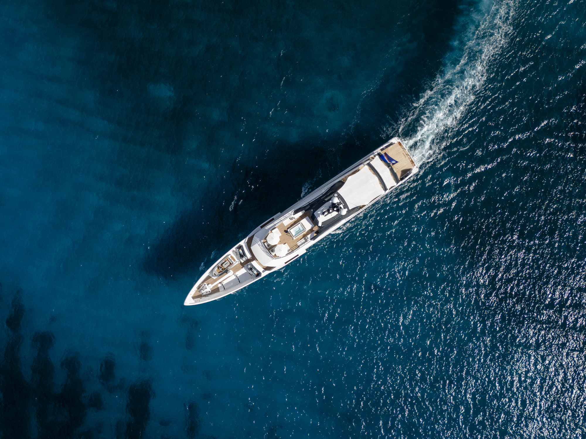 Birds-eye view of a yacht on deep blue water